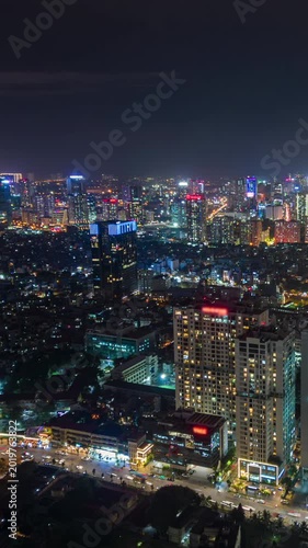 Aerial night timelapse of Hanoi, Vietnam with illuminated skyscrapers, busy streets, glowing city lights, and dense urban skyline in Southeast Asia.