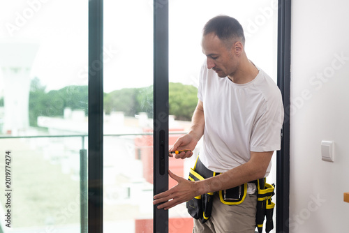 Construction worker installing window in house. Handyman fixing the window 
