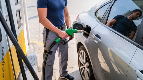 Tableau sur toile man filling gas tank,
Attendant refueling silver car with gas