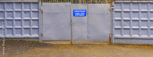 Foto Residential compound features sturdy concrete fence with warning label and visib