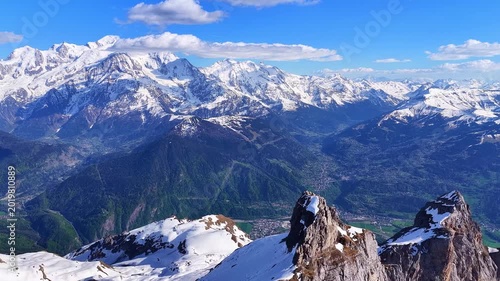 Cinematic 4K drone flight along dramatic snowy alpine cliffs with panoramic mountain landscapes rugged peaks deep valleys and spectacular natural scenery in the French Alps