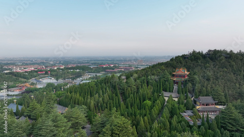 Aerial view of the Yellow Emperor Mausoleum surrounded by dense pine forests and traditional ancient architecture in Shaanxi Province