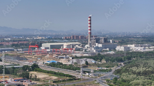 Fotografie Industrial plant with tall red-and-white striped chimney in panoramic view