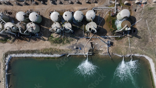 Foto Aerial view of industrial wastewater treatment ponds with storage tanks and aera