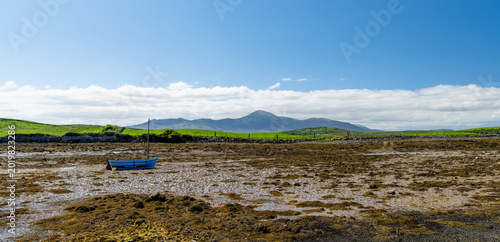 Foto A blue fishing boat rests on the mudflats at low tide in Clew Bay, County Mayo, Ireland