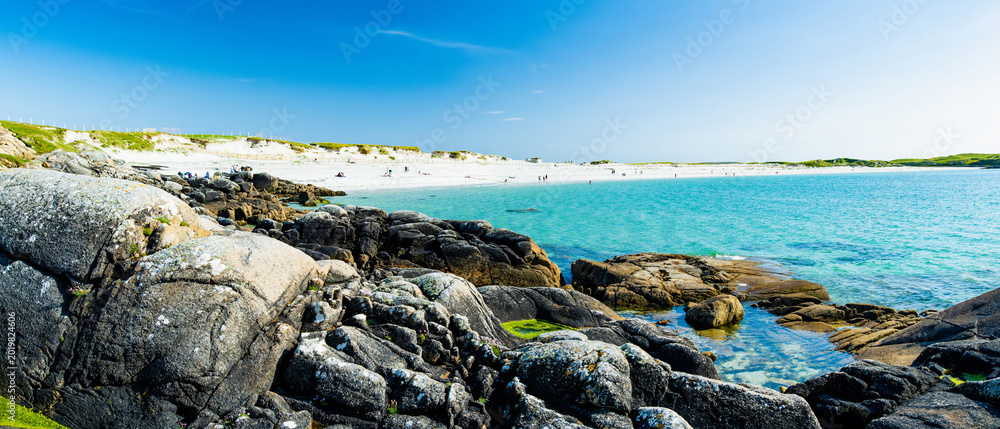 Fototapeta premium Rocky shoreline and turquoise water at Dogs Bay near Roundstone, Connemara, County Galway. Scenic white sand beach on the Wild Atlantic Way beside Gurteen Bay, Ireland