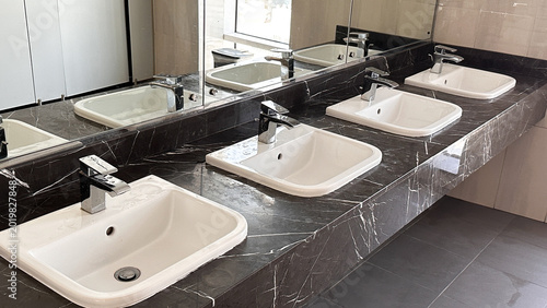 Modern bathroom with multiple sinks on marble countertop