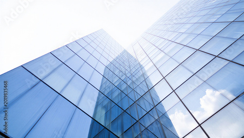 Fotografie Low angle view of a modern glass office building against a bright white sky with