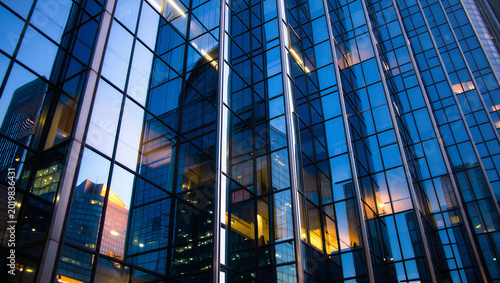 Tableau sur toile Close up architecture detail of blue glass skyscraper reflecting sunset sky and