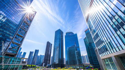 Bild auf Leinwand Low angle perspective of modern glass skyscrapers and skyscrapers in a sunny cit