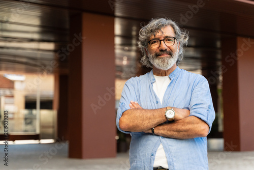 Fényképezés Portrait of cheerful senior man with grey hair and beard looking and smiling at