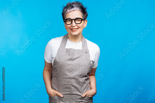 Obraz na plátně Middle-aged woman with short grey hair and glasses smiling confidently while wea
