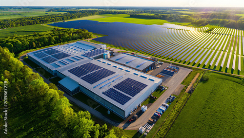 Φωτογραφία Aerial view of a large industrial building with solar panels on its roof, next t