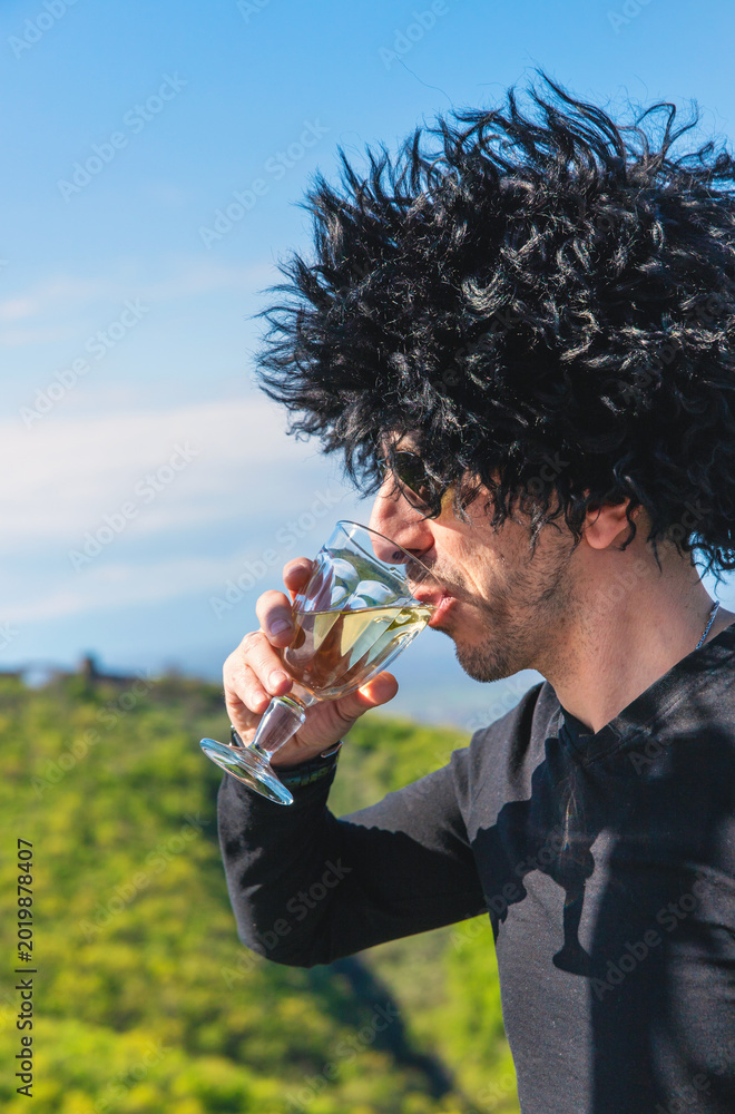 Fototapeta premium Georgian man in a papakhi with a glass of wine. Selective focus.