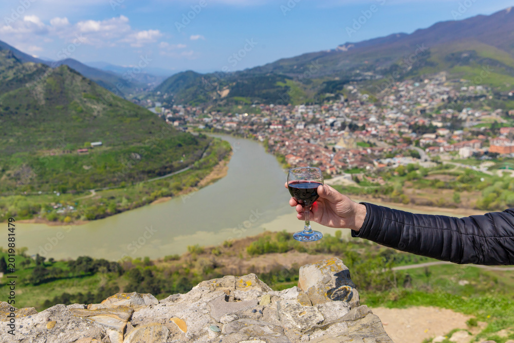 Obraz premium Georgian man in a papakhi with a glass of wine. Selective focus.