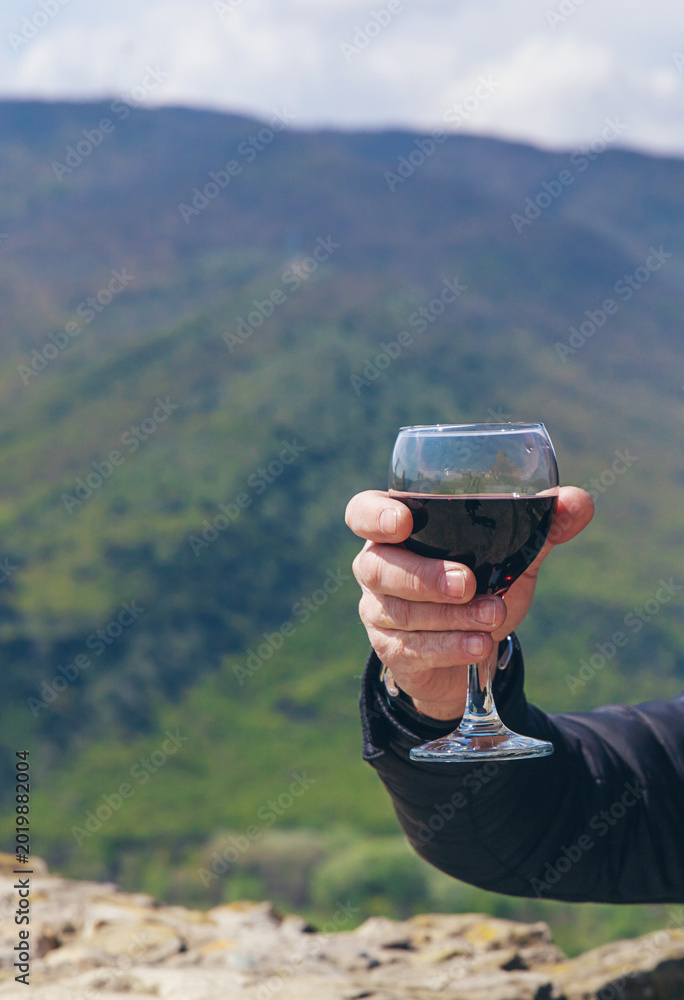 Fototapeta premium Georgian man in a papakhi with a glass of wine. Selective focus.