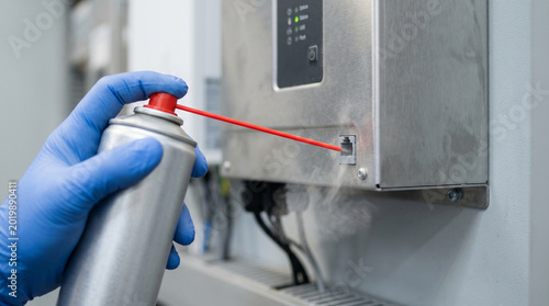 Gloved Hand Cleaning Ethernet Port with Compressed Air on Solar Inverter Cabinet