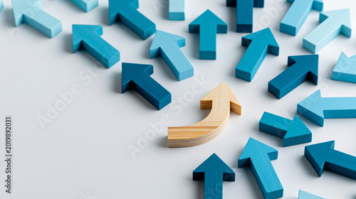 Wooden arrow changing direction among blue arrows symbolizing innovation leadership strategic thinking individuality disruption and business transformation in minimalist abstract concept