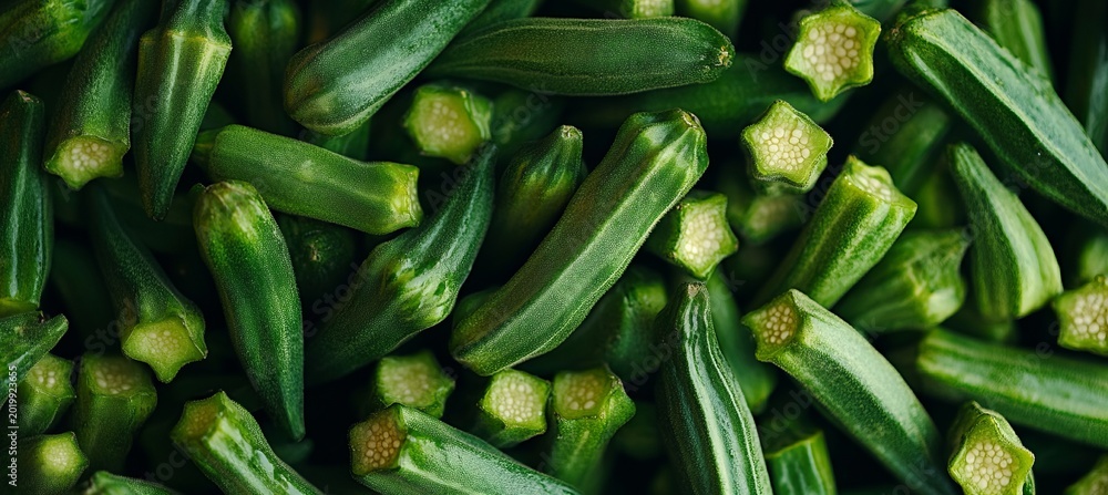 Fototapeta premium Close-Up of Fresh Organic Okra Pods in a Vibrant Green Garden, Showcasing Healthy Crops and Nature