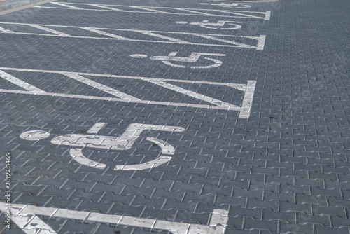 Parking spaces are marked clearly for people with disabilities in a busy parking lot