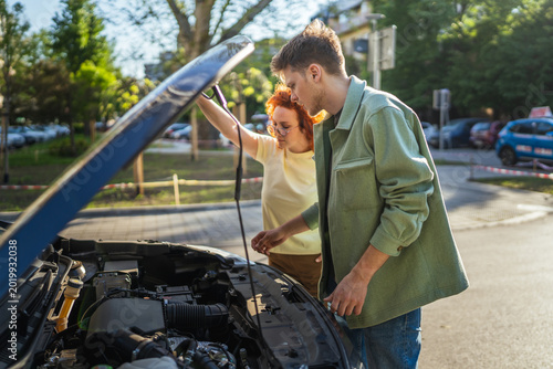 Photography Young couple fixing car engine trouble on roadside