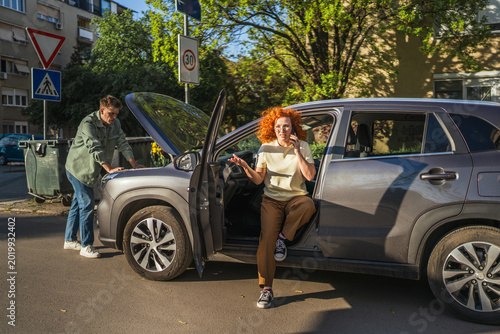 Photography Woman calling for roadside assistance after car breakdown