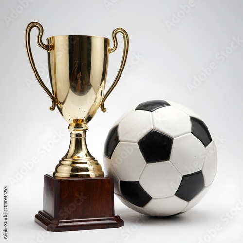 Soccer Trophy Beside a Classic Black and White Ball, Celebrating Victory and Sport Spirit