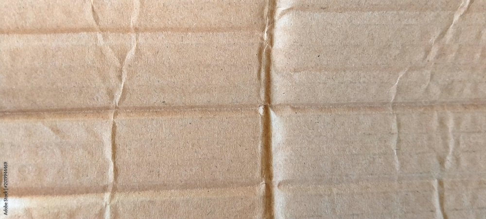 Fototapeta premium Textured corrugated cardboard surface with natural brown color