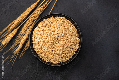 Bild auf Leinwand Wheat spikelets on a black stone background.