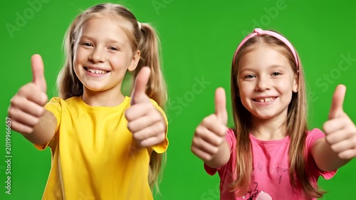 Two Happy Young Girls Giving Thumbs Up on Green Screen.