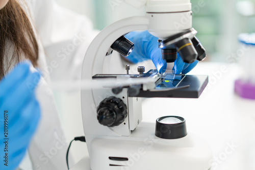 Fotografie researcher using microscope analyse cell in medical lab.