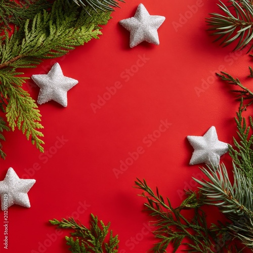 Decorative Silver Stars and Greenery Arranged on Red Background for Holiday S...