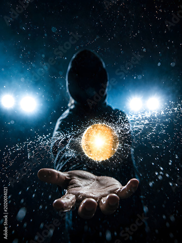 Dark cinematic scene with hooded silhouette holding glowing energy orb surrounded by water splashes and dramatic night lights.