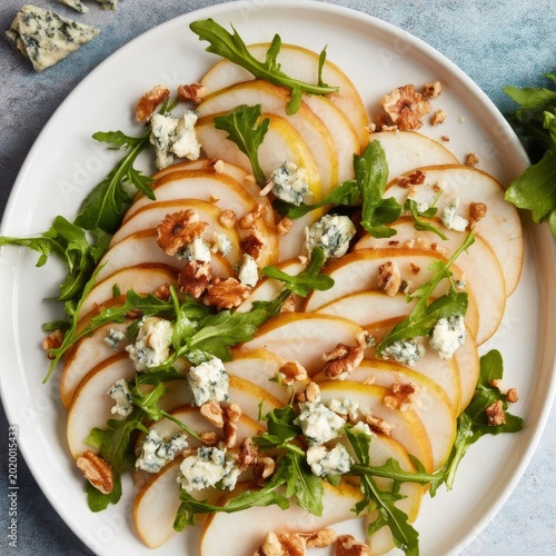Healthy Salad With Pear Slices, Walnuts, and Blue Cheese on a Round Plate Dur...