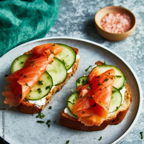 Two Slices of Bread With Salmon and Cucumber on a Plate at a Kitchen Table