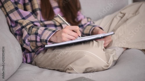 Working from home in a cozy office corner while taking notes in a personal notebook during productive hours