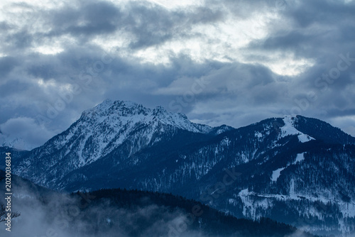 catene montuose nel nord Italia innevate, in inverno, al tramonto, con cielo nuvoloso