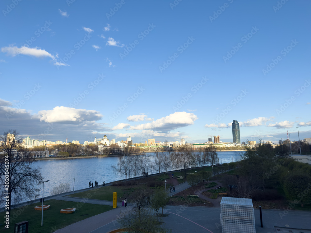 Wall Mural City skyline with river view and clouds under blue sky