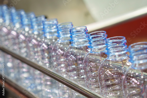 Foto Close-up incline view of a clear plastic PET drinking water bottle with light reflection and blue tone