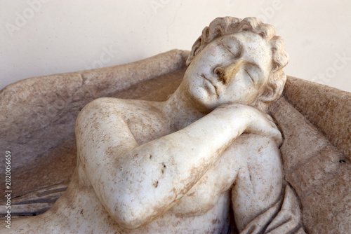 Fotografi Dettaglio di una scultura classica in marmo raffigurante una figura dormiente o