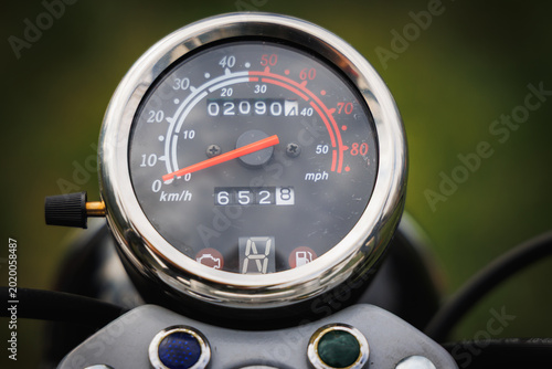 Картината върху платно Close up of a chrome motorcycle speedometer with odometer and red needle