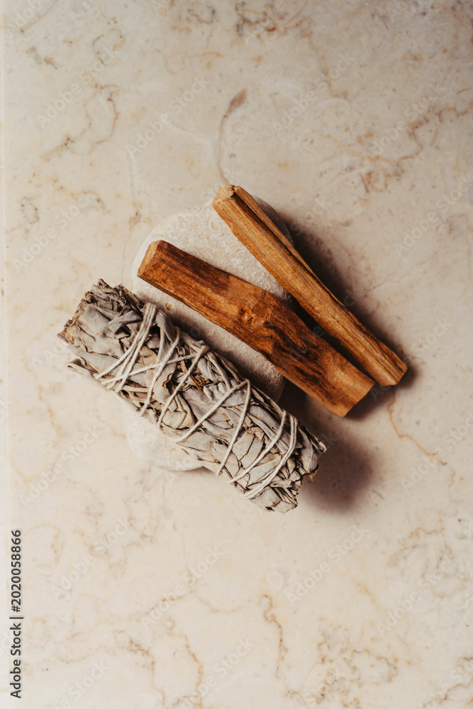 Φωτογραφία White sage bundle and palo santo sticks on a light marble background