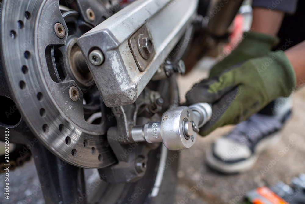 Fotografie Mechanic adjusts wheel