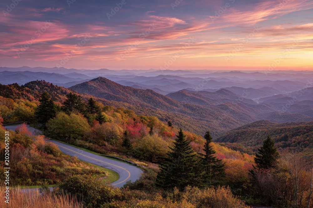 Fototapeta premium Distant blue silhouettes of forested ridges under a warm sunset sky