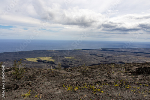Foto Wide panoramic view of the vast volcanic coastal plain meeting the sea in Hawai'