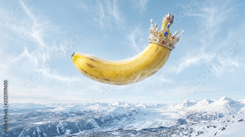 Whimsical floating banana with golden crown in blue sky, playful surreal fruit concept for creative food marketing and brand campaigns, fun quirky humor advertising