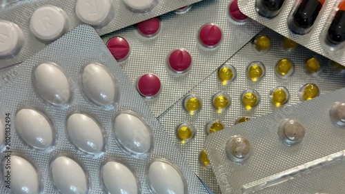 Colorful Tablets Scattered In Blister Packs, Orange And Black Capsules Next To Pink Tablets And Yellow Soft Capsules, Aluminum Foil Backing, Reflective Glossy Surfaces, Close-Up Clinical Lighting