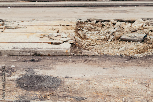 Bild auf Leinwand Construction activities are underway at an urban road site where the pavement is broken and sections of the ground are exposed