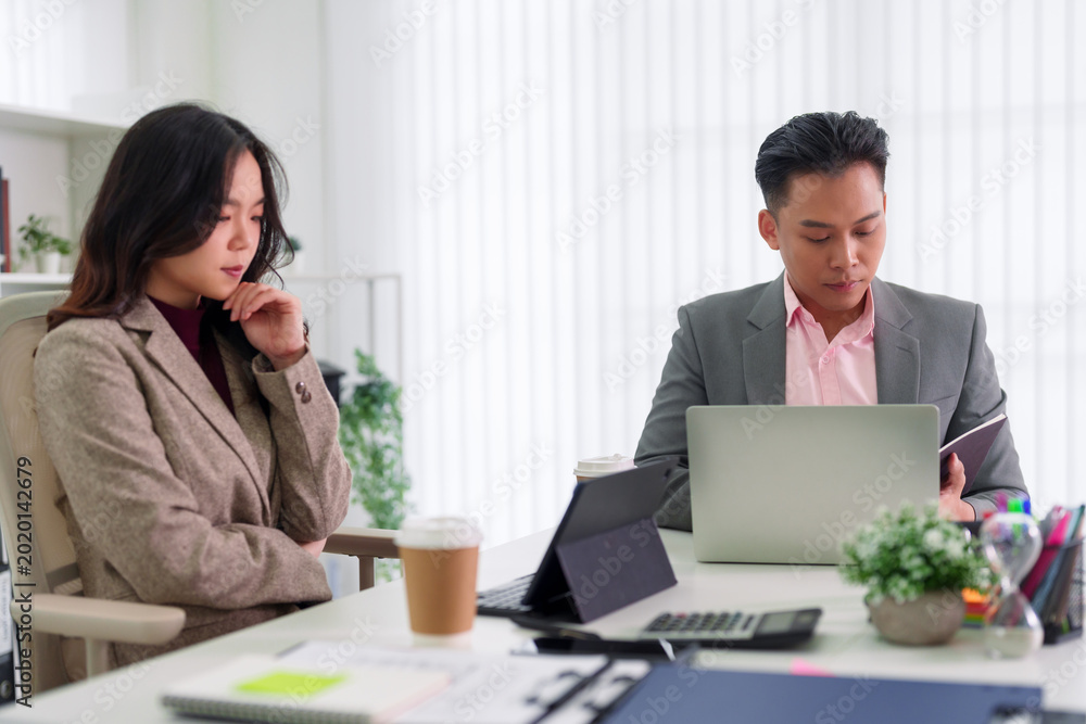 Fototapeta premium Asian business professionals collaborating on digital tablet laptop project meeting working together discussing strategy planning presentation at modern office