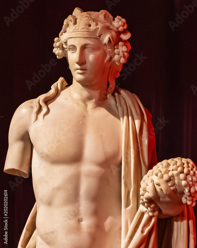 Classical Marble Statue of Dionysus with Grapes under Warm Dramatic Lighting